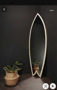 a mirror sitting on top of a table next to a potted plant