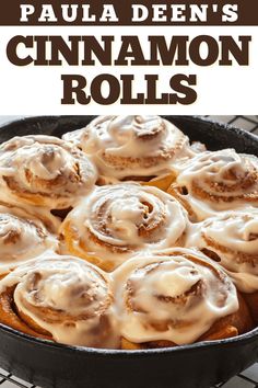 a pan filled with cinnamon rolls on top of a cooling rack and topped with icing