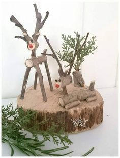 two wooden reindeer sculptures sitting on top of a tree stump