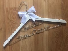 two personalized wedding hangers with white bows