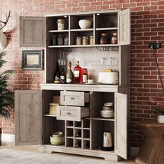 an open cabinet with wine bottles and other items on the shelves in front of a brick wall