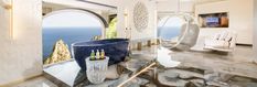 a bathroom with a large bath tub next to the ocean