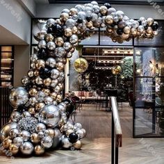 an entrance to a restaurant decorated with silver and black balloons