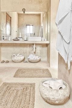 a bathroom with two rugs on the floor and a sink in the background,