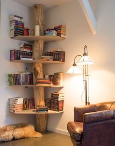 a living room filled with furniture and bookshelves next to a wall mounted lamp