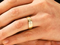 a man's hand with a wedding ring on it