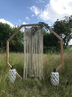 two white vases sitting on top of a grass covered field next to a wooden structure