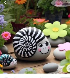 some rocks with flowers and plants in them on a table next to the words, rock painting ideas for kids