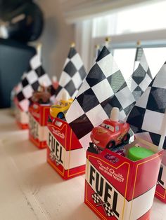 some cars are lined up on top of each other in tin canisters with flags