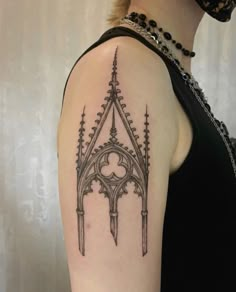 a woman's arm with a tattoo on it that has a gothic style design