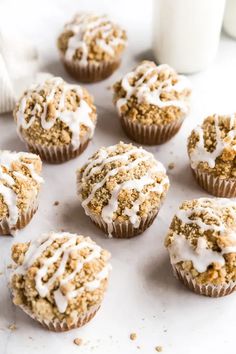 muffins with white frosting and crumbs on top