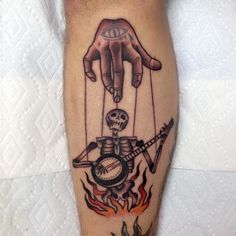 a tattoo on the leg of a person with a hand holding a clock and arrow