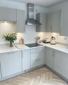 a kitchen with grey cabinets and white counter tops