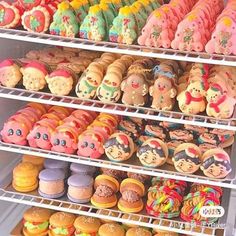 there are many different types of cookies on the shelves in this case, including one with clown faces