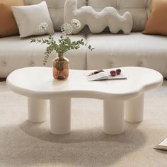 a white coffee table sitting on top of a carpeted floor next to a couch