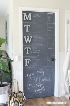 a chalkboard door with writing on it next to a potted plant