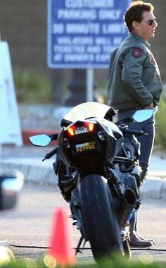 a man standing next to a parked motorcycle