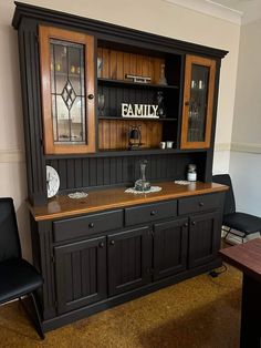 a dining room hutch with wooden paneling and glass doors