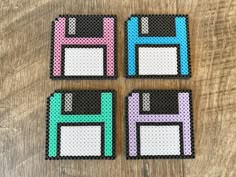 four pieces of perler bead sitting on top of a wooden table