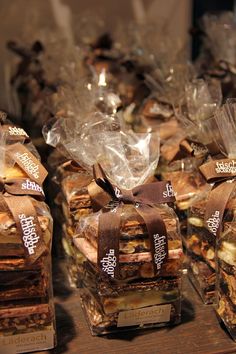 several pieces of food wrapped in plastic and tied with brown ribbon sitting on a table