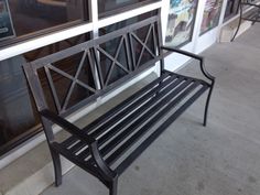 a metal bench sitting in front of a store