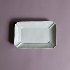 a white plate sitting on top of a purple table