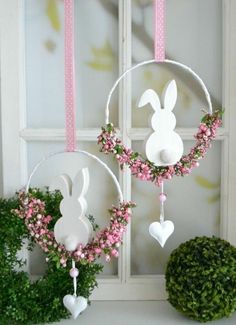 an easter decoration with pink flowers and bunny ears