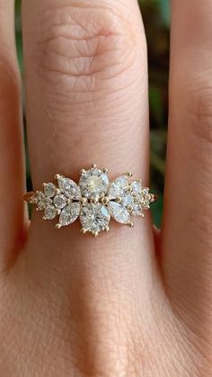 a woman's hand with a gold ring on it and three diamonds in the middle