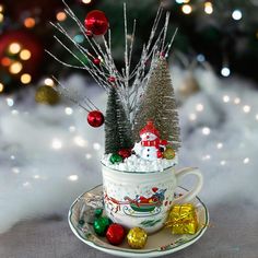 a cup filled with marshmallows and christmas decorations on top of a saucer