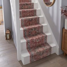 a staircase with carpeted steps leading up to a mirror on the wall above it