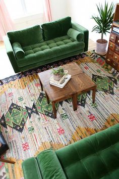 a living room with two green couches and a coffee table in the center area