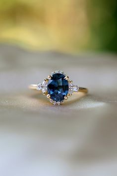 a blue and white diamond ring sitting on top of a table