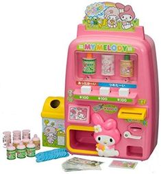 a pink toy vending machine with hello kitty on the front and other items surrounding it