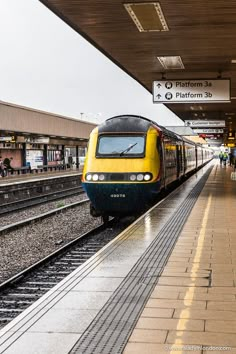 a yellow and black train pulling into the station