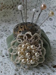 an old sewing needle holder with buttons and pearls