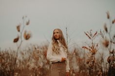 a woman standing in the middle of a field