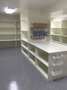 an empty storage room with several shelves and bins