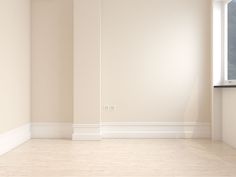 an empty room with white walls and wood floors