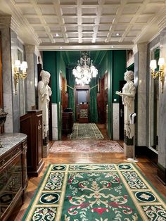 the hallway is decorated in green and gold with statues on either side of the door