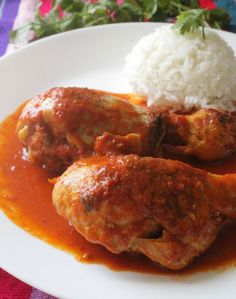 a white plate topped with meat covered in sauce and rice