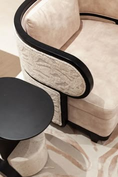 an upholstered chair and side table are on display in a room with zebra rugs