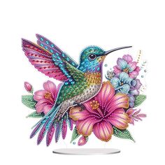 a colorful hummingbird sitting on top of flowers