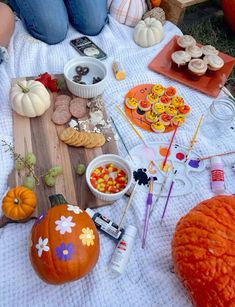 the table is set up with pumpkins, candy and snacks