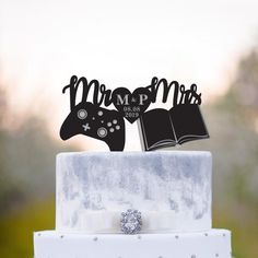 a wedding cake topper with two video game controllers and mr and mrs on it