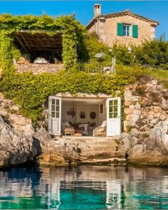 the house is surrounded by rocks and greenery