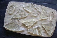 several pieces of glass sitting on top of a wooden cutting board