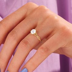 a woman's hand with a blue manicured nail polish and a diamond ring