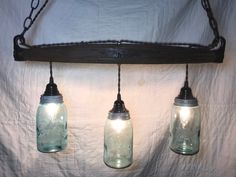 three mason jar lights hanging from a chain