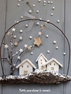 some little white houses are on top of a piece of driftwood with stars and snow