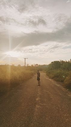 a person standing on the side of a dirt road